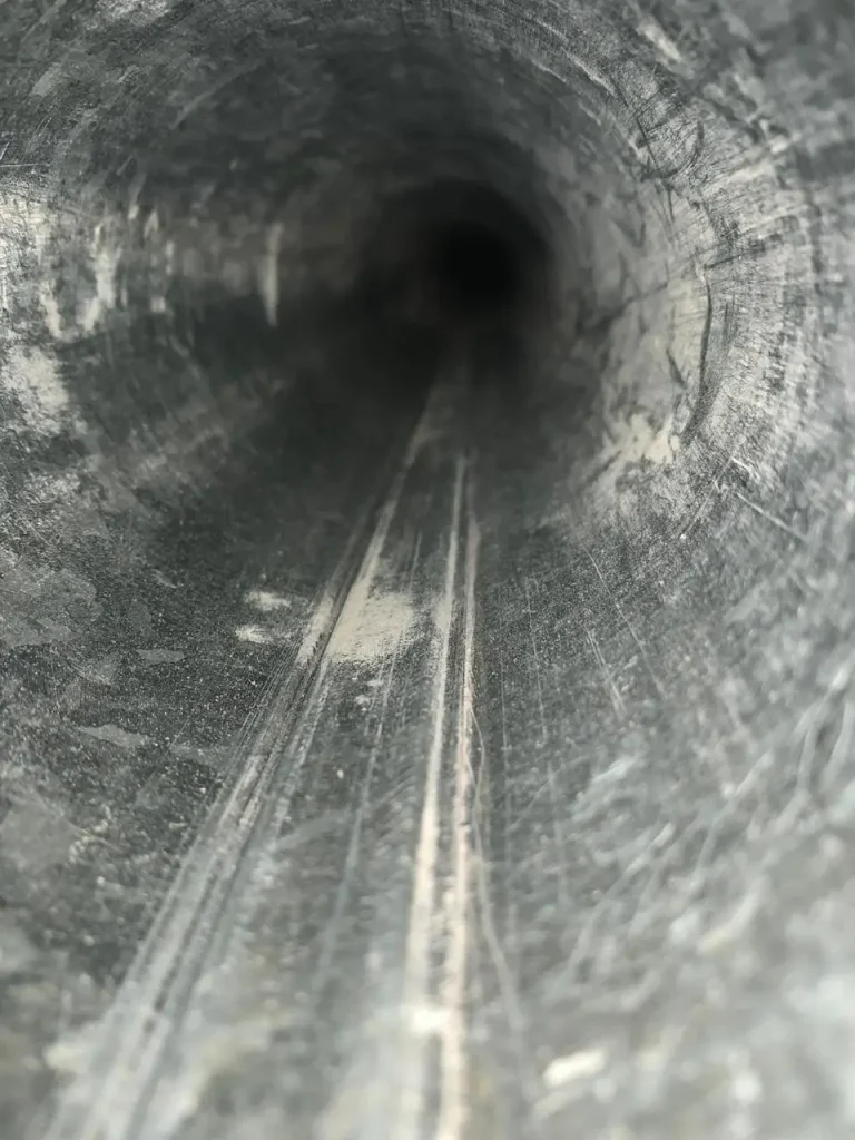 Inside view of a chimney flue coated with creosote and soot buildup along the interior walls.